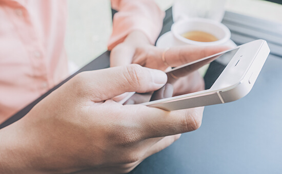 leisure, technology, lifestyle and people concept - close up of hand with smartphone messaging at coffe shop